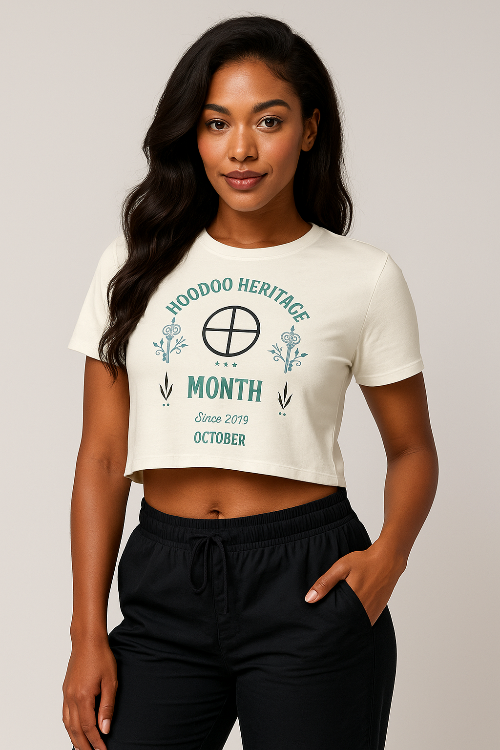 Woman wearing a white t-shirt with 'Hoodoo Heritage Month' text on a plain background